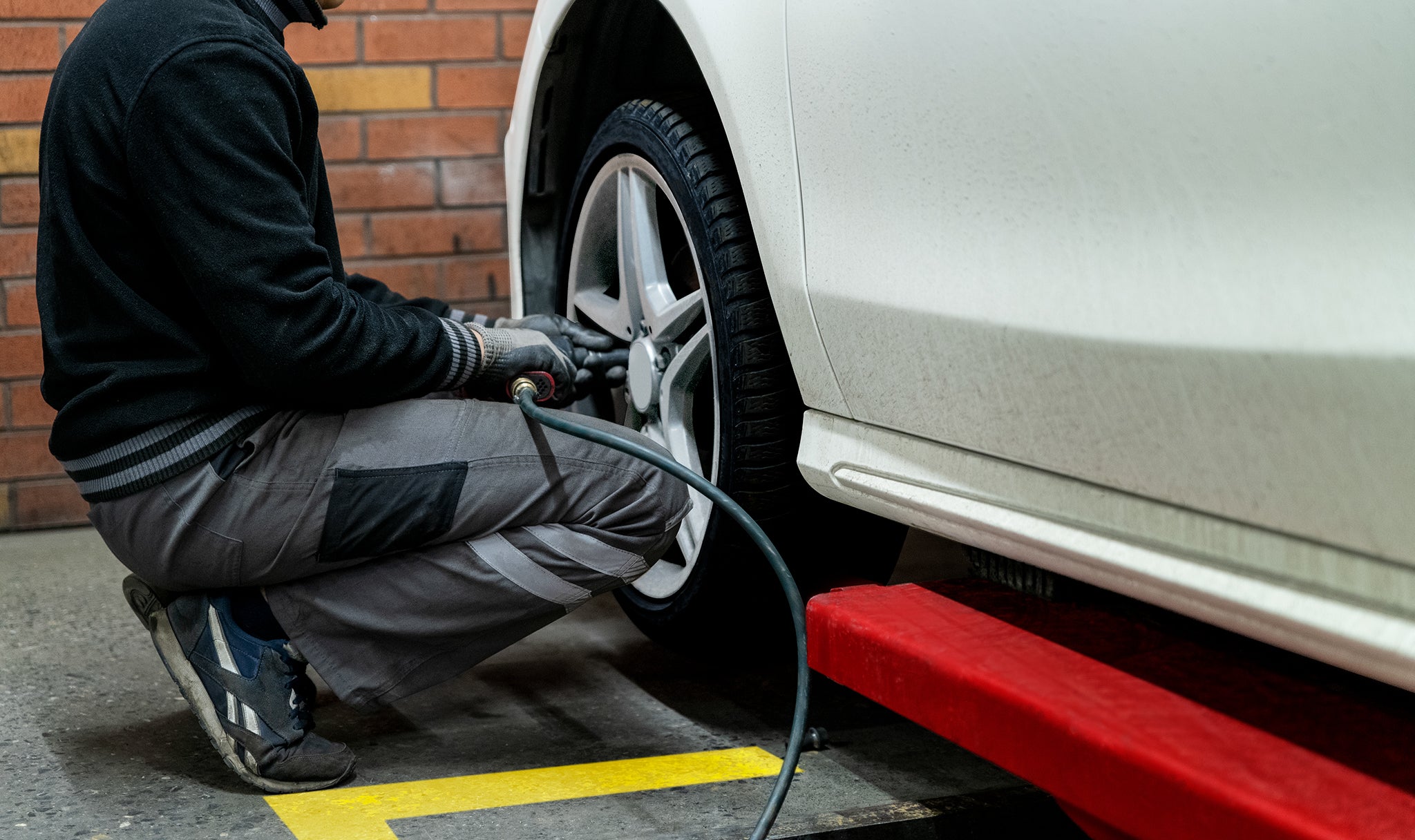 Tighten screws A man is tightening the screws at front tire.