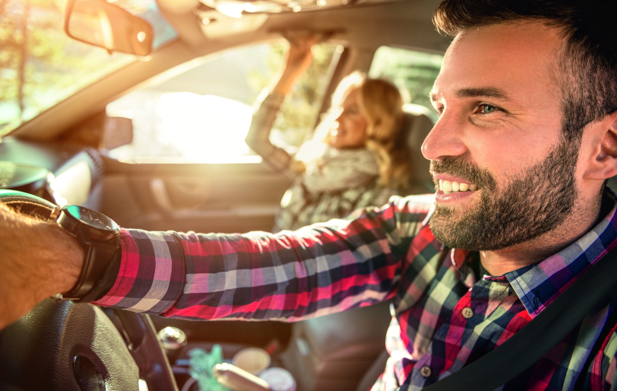 Happy couple in the car traveling together,