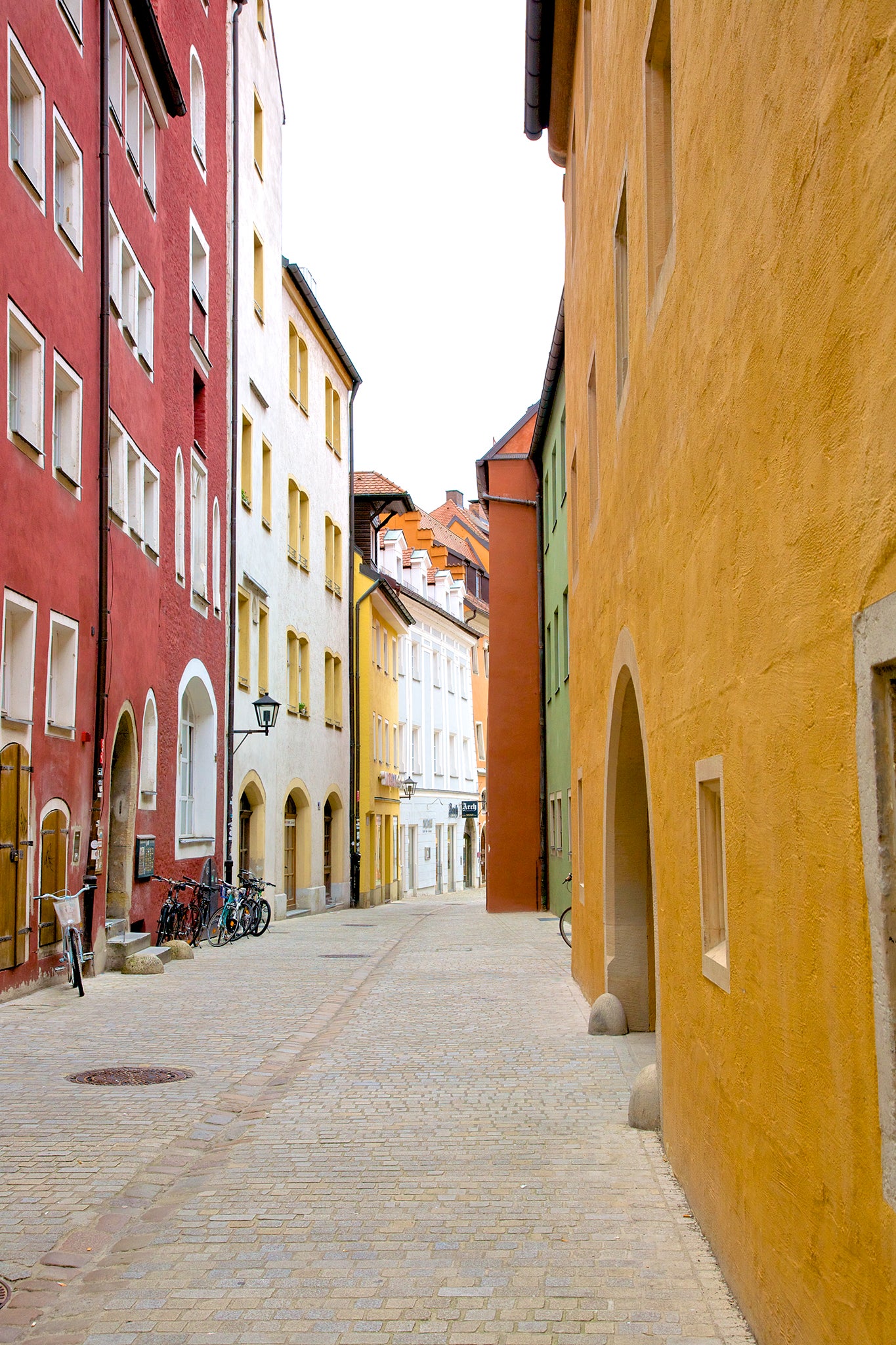 Colorful painted houses Colorful painted facades on charming cobblestone pedestrian street in Old Town of Regensburg, a Bavarian city on Danube River in southeast Germany.