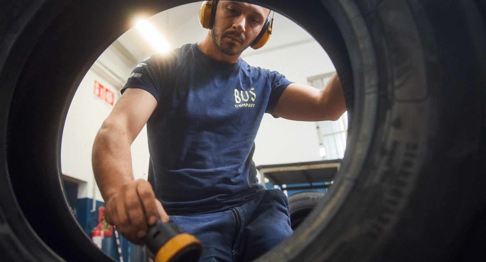 Employee working with a bus tire