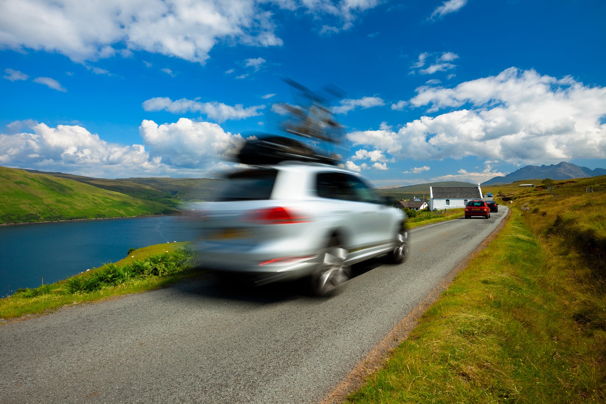 SUV car driving with bike on roof on Isle of Skye; Blurred Motion, Scotland, UK,click below to view more related images: