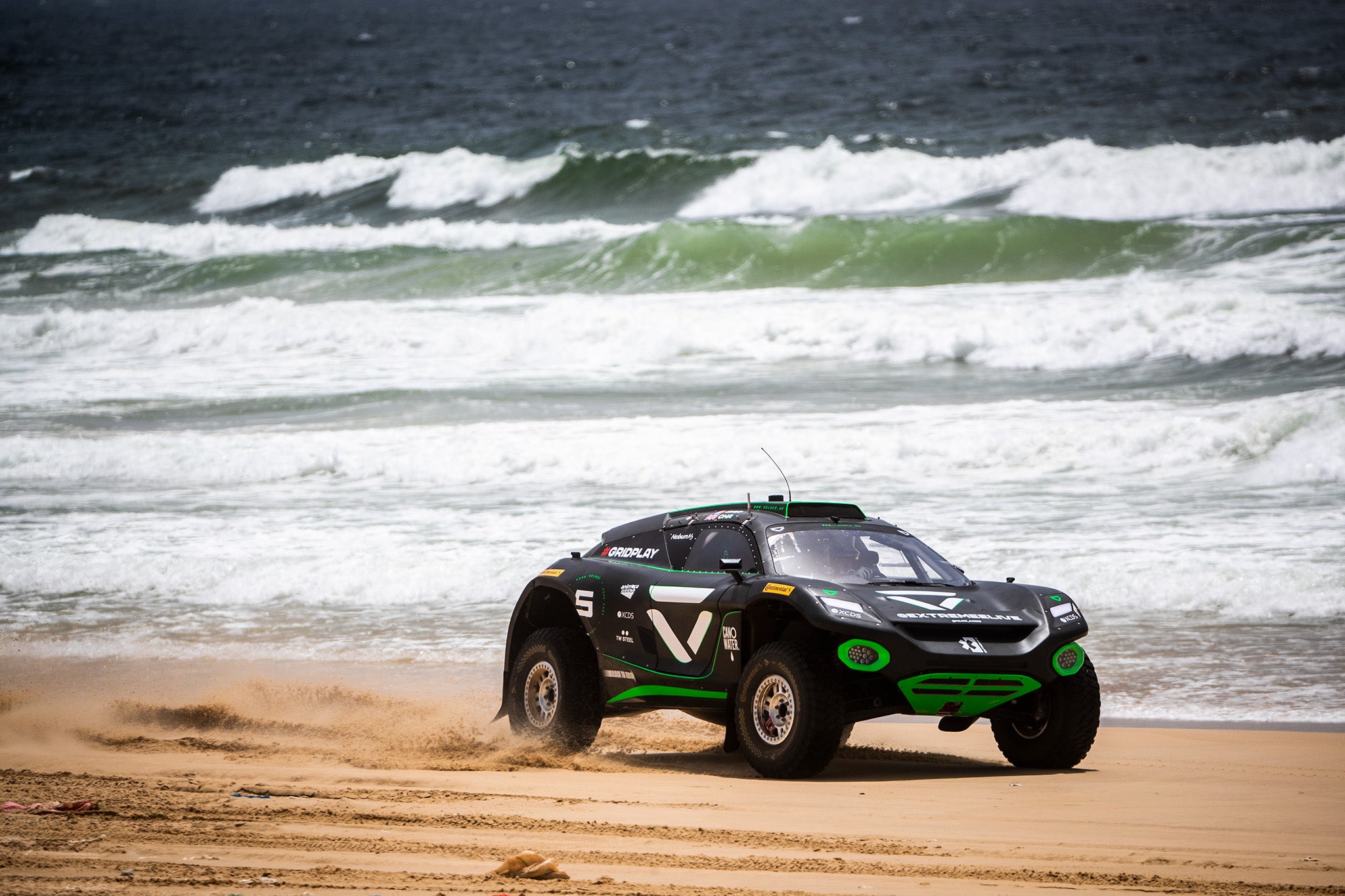 Un'auto da corsa Extreme E che guida lungo la spiaggia in Senegal