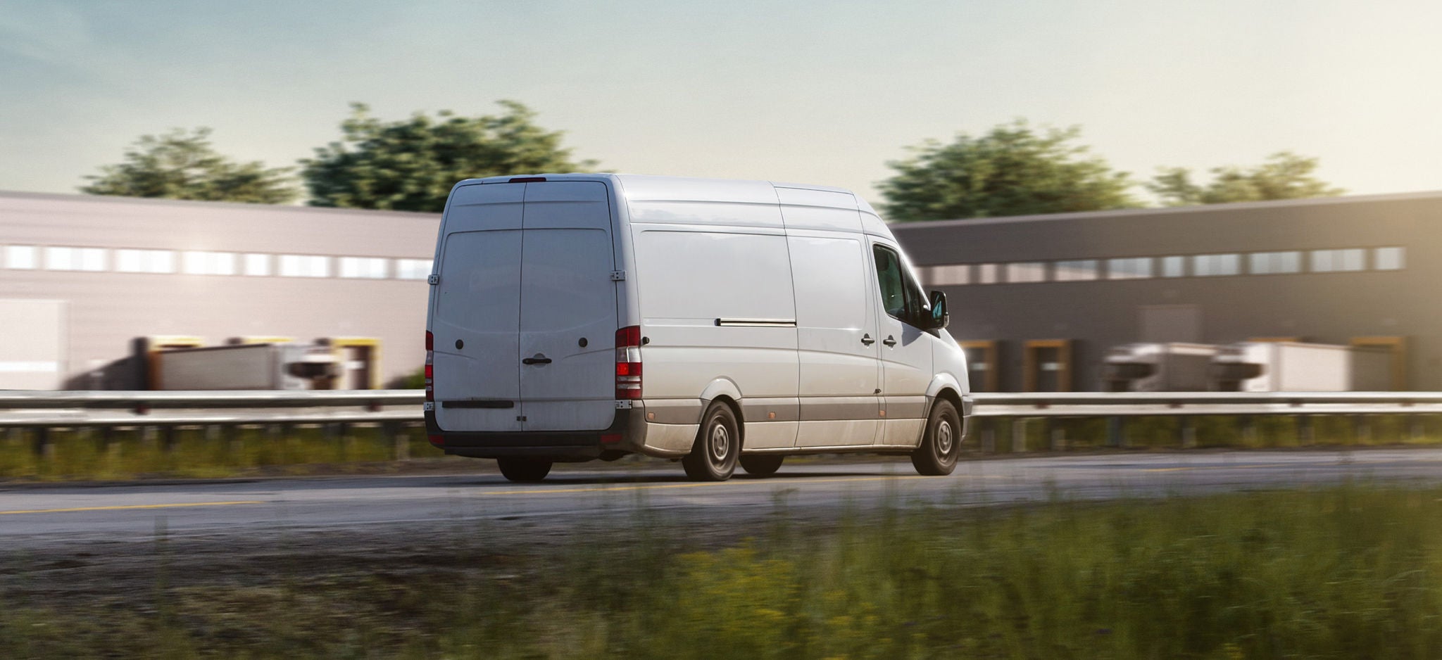 Van-Website Header picture white Van driving on a road