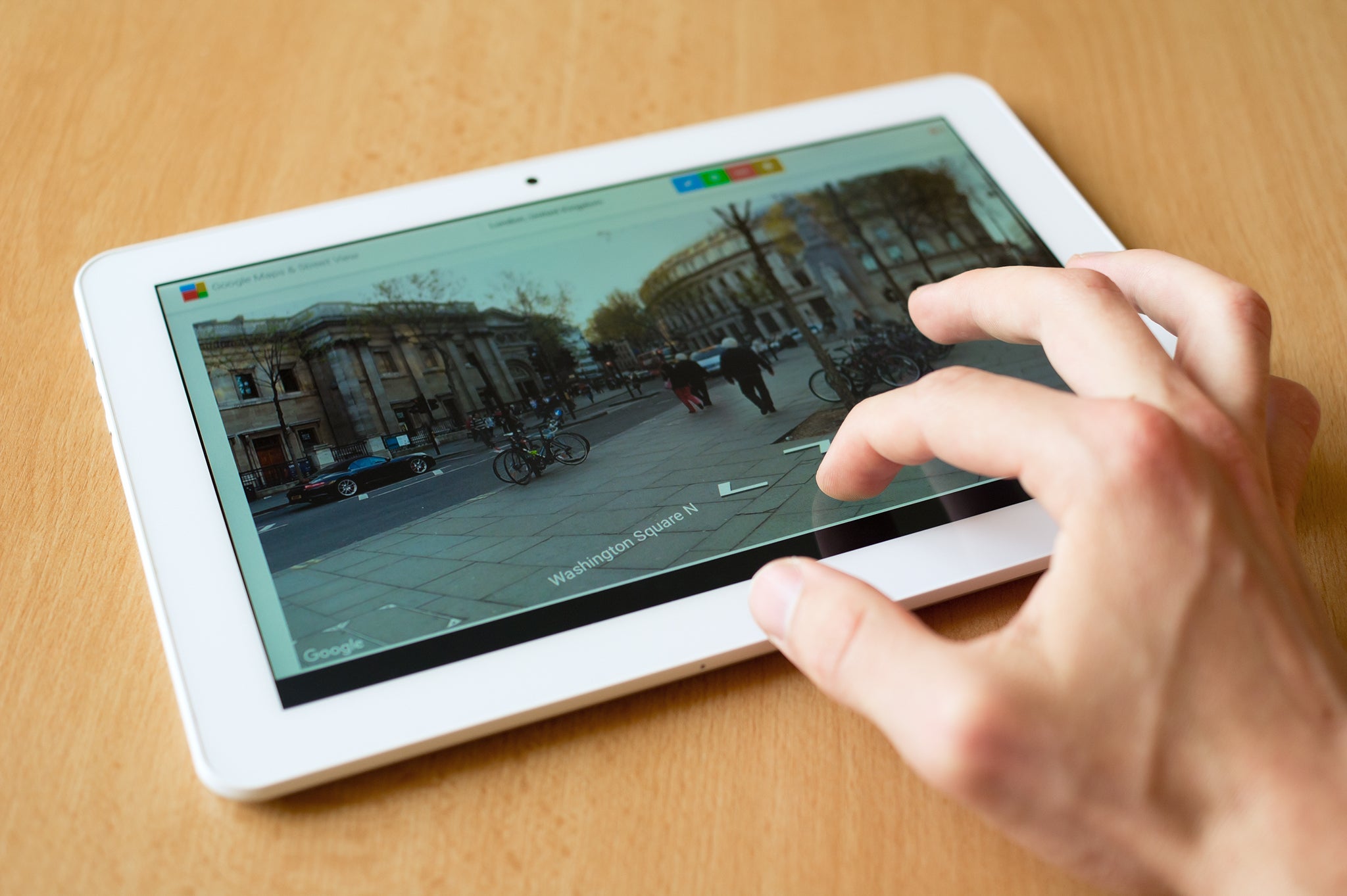 Tablet Man's hand use with his fingers tablet. Street View homepage is on the screen..