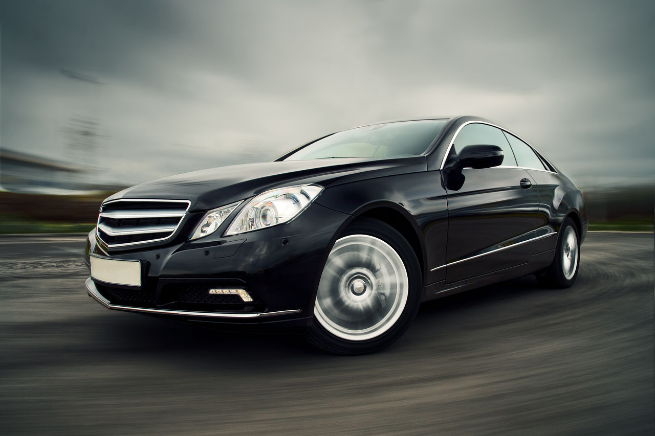Front view of black luxury coupe driving fast