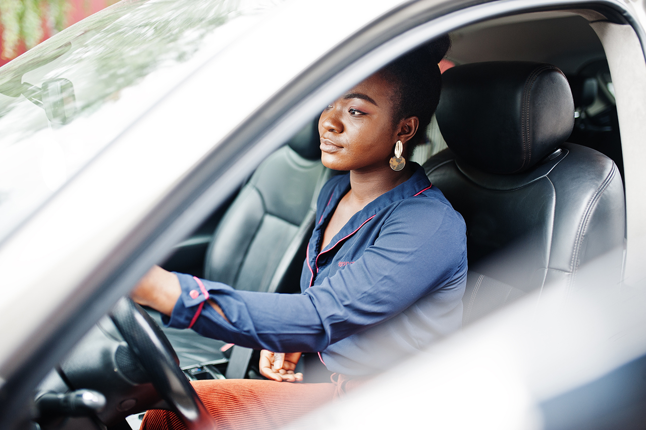 Woman sit on driver seat at silver suv car with opened door.