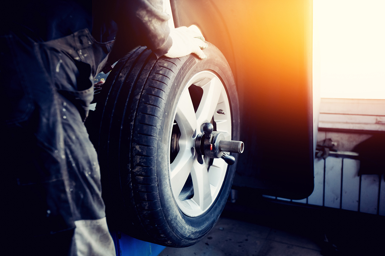 repairman balances the wheel and installs the tubeless tire of the car on the balancer in the workshop.